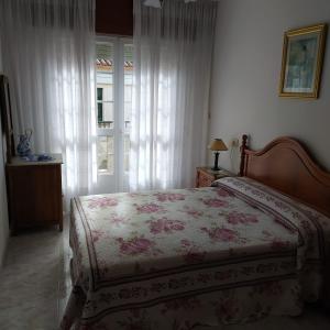 een slaapkamer met een bed en een raam bij Acogedor apartamento céntrico in O Grove