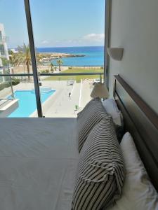 a bed in a room with a view of the ocean at Coralli Superior Seaview in Protaras