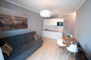 un soggiorno con un divano e un tavolo di Apartament IKAR - 2 pokojowy przy morzu z balkonem a Pobierowo
