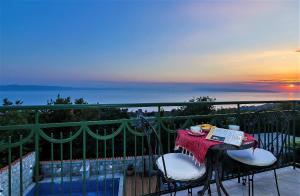 a table and chairs on a balcony with the sunset at Villa Lavanda in Podgora