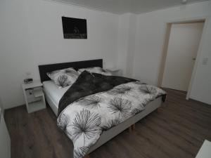 une chambre avec un lit avec une couette noire et blanche dans l'établissement Ferienwohnung Sanwald, à Schwäbisch Hall