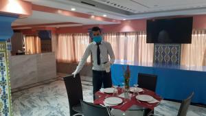 Ein Mann mit einer Maske in einem Zimmer mit einem Tisch. in der Unterkunft HOTEL DELTA ATLAS in Casablanca