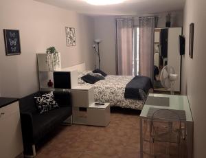 a small bedroom with a bed and a couch at Studios Terrasses du Rempart in Avignon