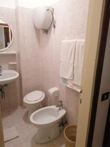 biała łazienka z toaletą i umywalką w obiekcie Camere da Anna Maria w Asyżu