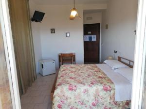 sypialnia z łóżkiem z narzutą kwiatową w obiekcie Camere da Anna Maria w Asyżu