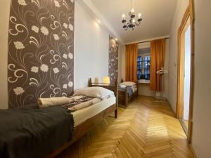 a bedroom with a bed and a wall with a flower pattern at P&J Apartamenty Grodzka in Kraków
