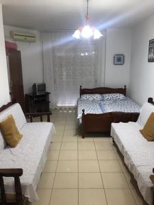- un salon avec deux lits et une fenêtre dans l'établissement Geni Apartment, à Durrës