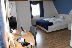 a bedroom with a bed and a table with a telephone at Hotel Restaurant Post Italia in Albstadt