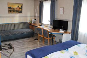 a room with a bed and a desk with a computer at Hotel Restaurant Post Italia in Albstadt