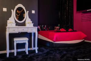 a bedroom with a bed and a dressing table and a mirror at Désir'ôôm in Cabannes +26 photos