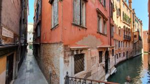 ヴェネツィアにあるWellVenice Feniceの運河の横の建物のある街路