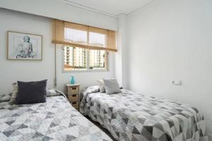 ein Schlafzimmer mit zwei Betten und einem Fenster in der Unterkunft APARTAMENTO ROMA XI in Playa de Gandia + 12 Fotos