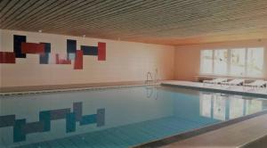 uma grande piscina com cadeiras num quarto em Ferienwohnung Alpenveilchen im Oberallgäu em Missen-Wilhams