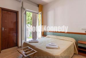 a bedroom with a bed and a large window at Hotel Kennedy in Lido di Savio