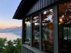 une maison avec des fenêtres donnant sur un lac dans l'établissement Lovely villa in Lavaux with unique view !, à Chardonne