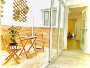 a patio with a table and chairs in a room at Apartamentos Villas Romanas in Merida