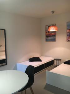 ラ・シオタにあるT2 L'Escapadeのベッド、テーブル、椅子が備わる客室です。