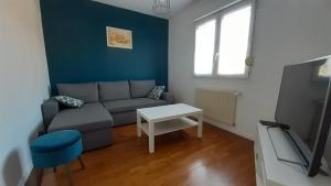 a living room with a couch and a table and a tv at Escapade in Bréhal