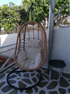 a wicker chair on a balcony with a table at Bay's in Spetses