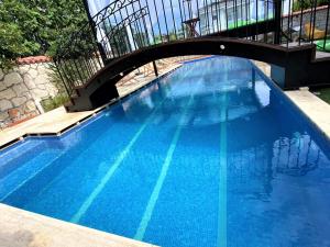 a large blue swimming pool with a bridge at Grand Alaçatı Butik Hotel in Alaçatı