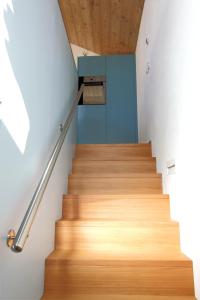 a staircase with wooden floors and a blue wall at Ferienhaus Z‘ Gädi in Ernen