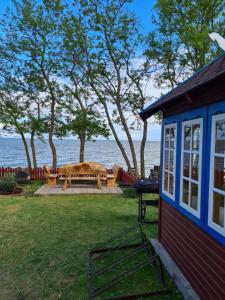 a house with a picnic table next to the water at Preila Kristima-3 in Preila