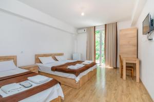 a hotel room with two beds and a window at Hotel Continental in Gori