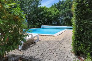 a swimming pool with a white bench next to it at Villa piscine face au grand luberon Cereste in Céreste