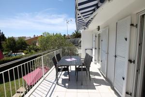 een patio met een tafel en stoelen op een balkon bij Apartment Bianca Premantura Istrien in Premantura