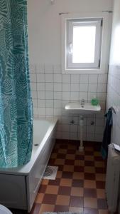 ein Badezimmer mit einer Badewanne und einem Waschbecken in der Unterkunft Rumskulla guesthouse in Vimmerby