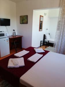 een hotelkamer met een bed met handdoeken erop bij Panos in 2 Mai