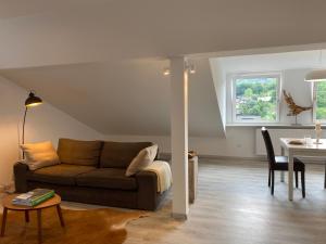 a living room with a couch and a table at Natur Panorama Suiten am Rursee in Heimbach