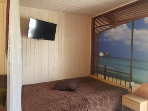 a bedroom with a bed and a tv on the wall at Poilsiavietė Mano Maljorka in Šventoji
