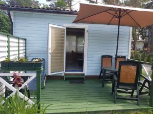 a patio with an umbrella and a table and chairs at Poilsiavietė Mano Maljorka in Šventoji