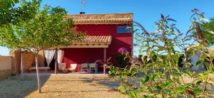 czerwony dom z ogrodem przed nim w obiekcie La Era De Pepe w mieście Calaceite