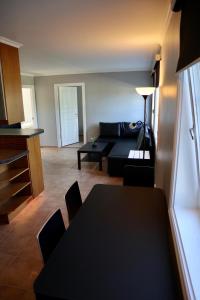 een woonkamer met een bank en een tafel bij Praktisk leilighet i Kristiansand til 5 in Kristiansand