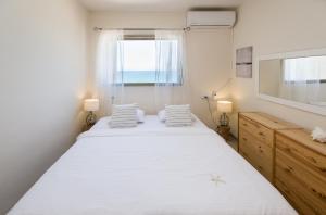 Un dormitorio con una cama grande y una ventana. en Luminous Sea, en Haifa