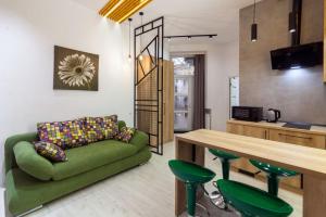 a living room with a green couch and a table at Apartments on Kulisha str in Lviv