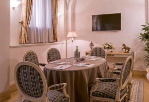 a dining room with a table and chairs and a television at Hotel Armonia in Pontedera