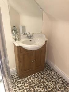 ein Bad mit einem Waschbecken und einem Spiegel in der Unterkunft Drum Manor Apartment Hillsborough BT26 6PU in Hillsborough