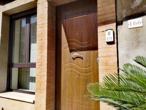 una porta di legno sul lato di una casa di Loft_166 a Sellia Marina