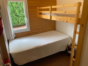 - une petite chambre avec des lits superposés et une fenêtre dans l'établissement Les Refuges des Catieres, à Amance