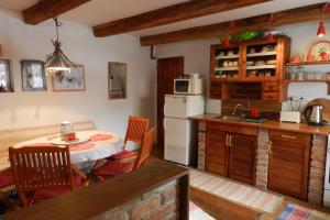 a kitchen with a table and a white refrigerator at Chalupa v raji in Dedinky