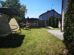 a yard with a table and chairs and a house at Rivabell in Ostrowo