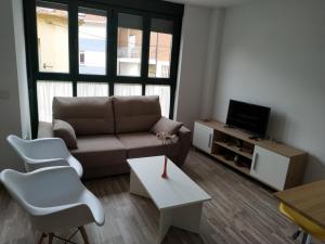 a living room with a couch and a tv at Edificio Valles del Lúpulo in Astorga