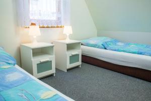 een slaapkamer met 2 bedden en 2 nachtkastjes bij Domek AMPERO in Władysławowo