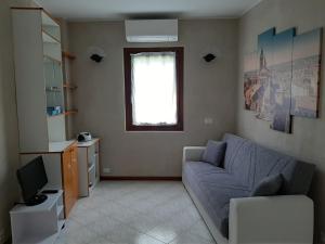 een woonkamer met een bank en een televisie bij Casa Bibì in Bergamo
