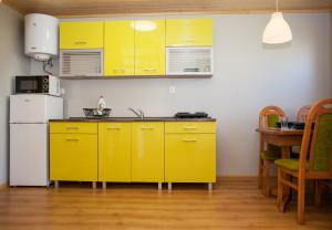 een keuken met gele kasten en een witte koelkast bij Domek AMPERO in Władysławowo