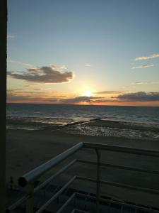 einen Sonnenuntergang am Strand mit dem Meer in der Unterkunft L Ô in Ostende