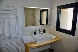 a bathroom with a white sink and a mirror at Gîtes Du Mas de Surlan in Chantemerle-les-Blés +35 photos